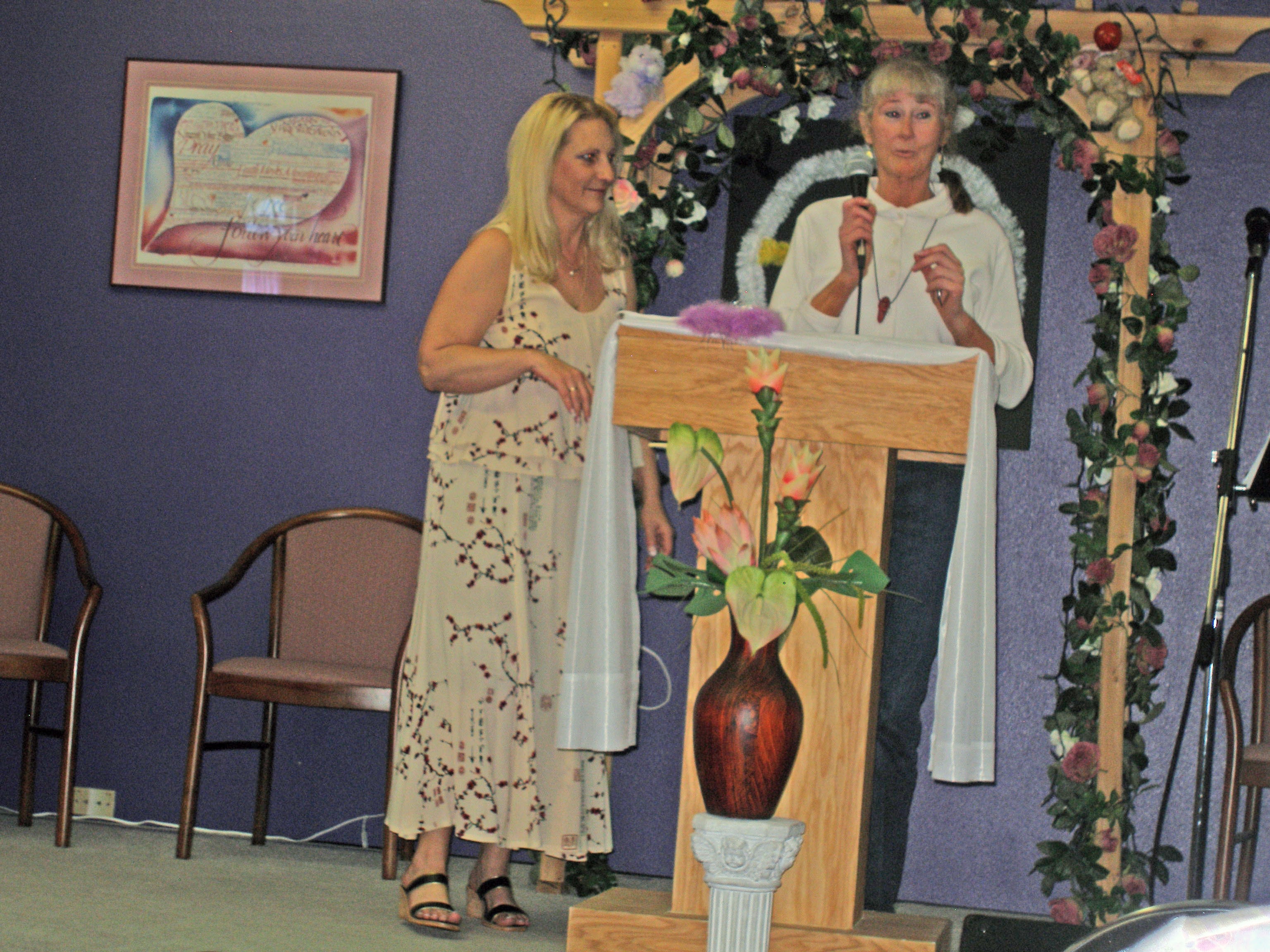 Two women at decorated podium during Oasis CSL service