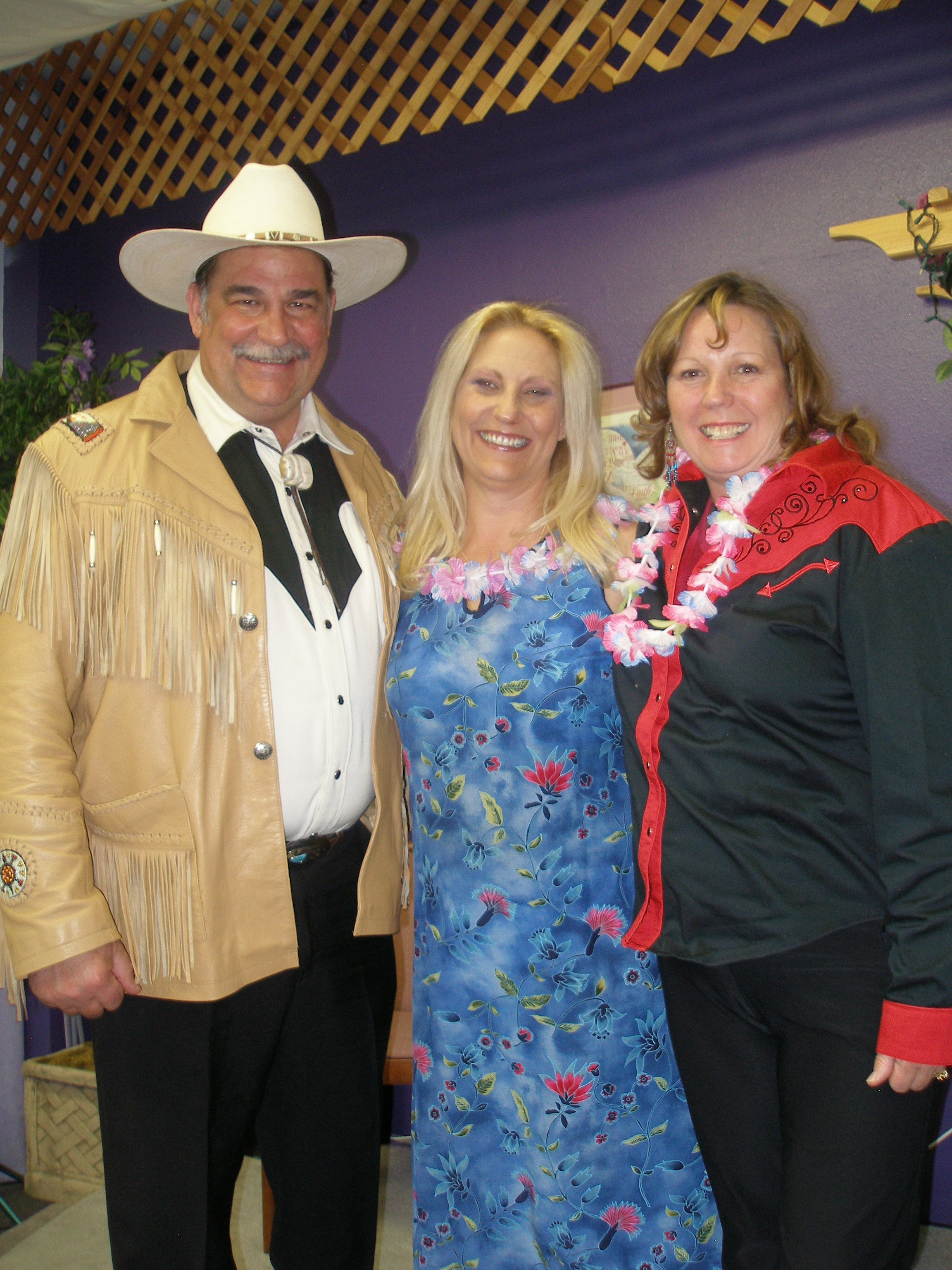 Three people with cowboy hat and lei at Oasis CSL event