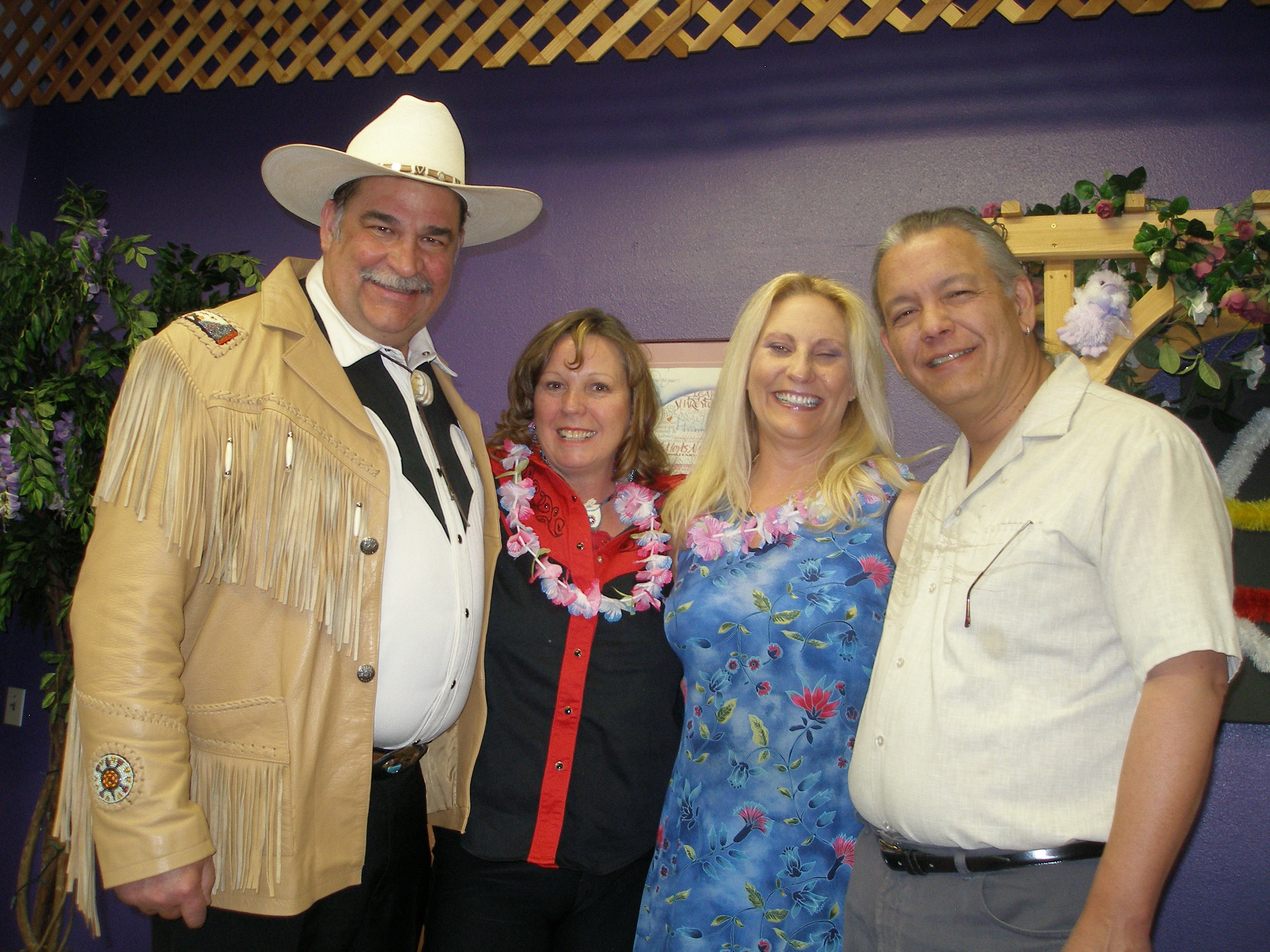 Four people with cowboy hat and lei at Oasis CSL event