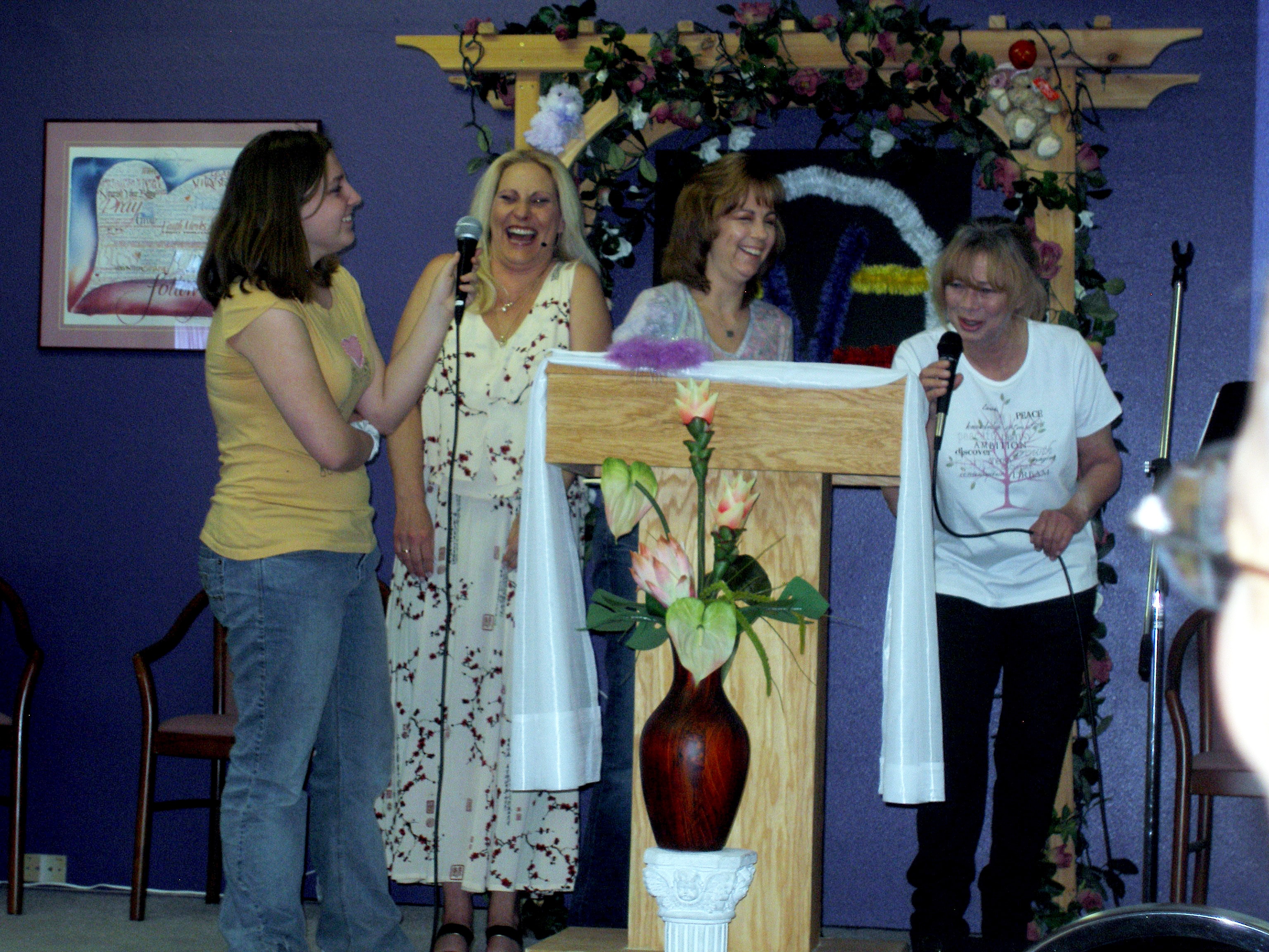 Four women laughing together at Oasis CSL podium