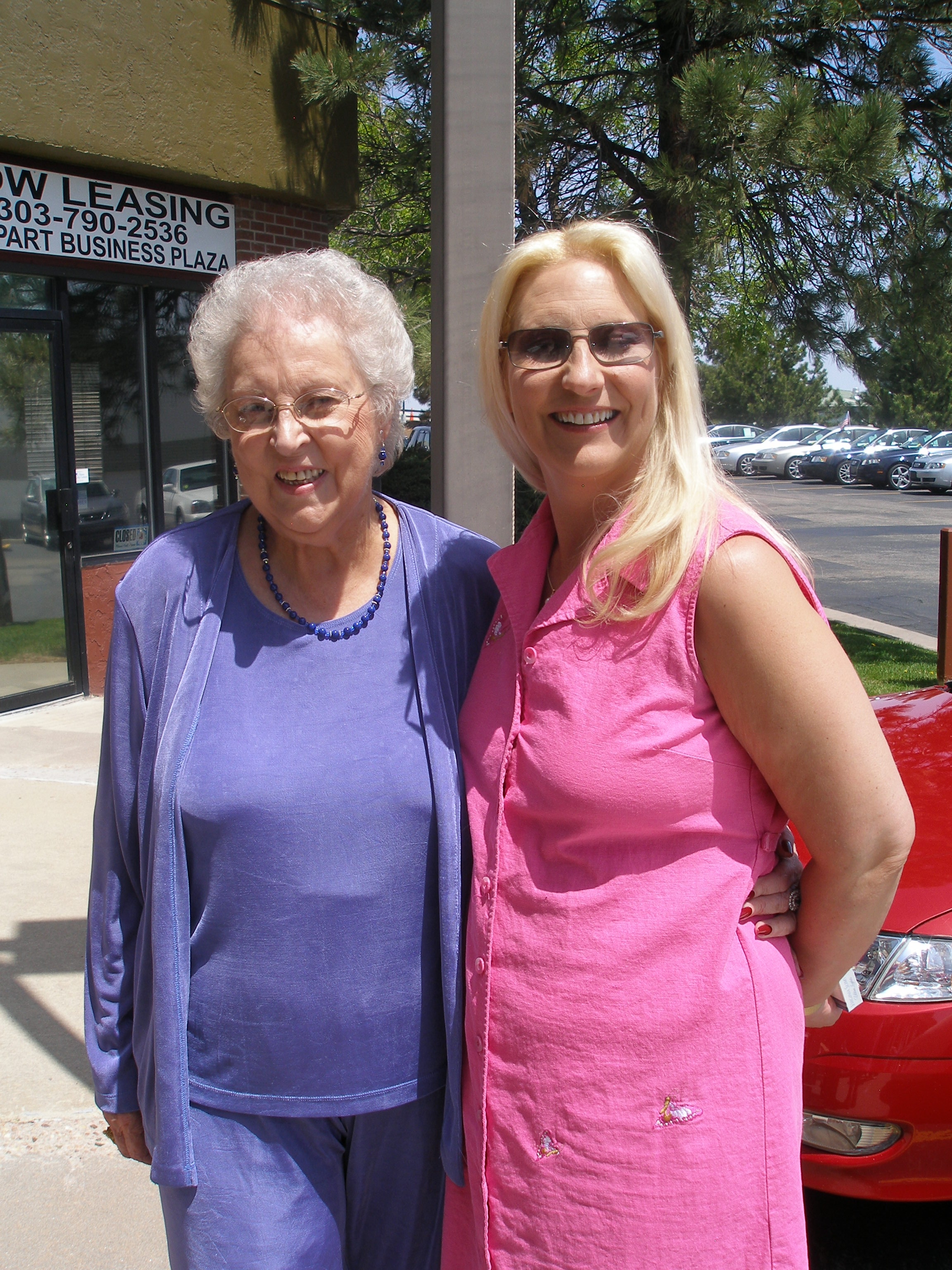 Two women posing outside the Oasis CSL building