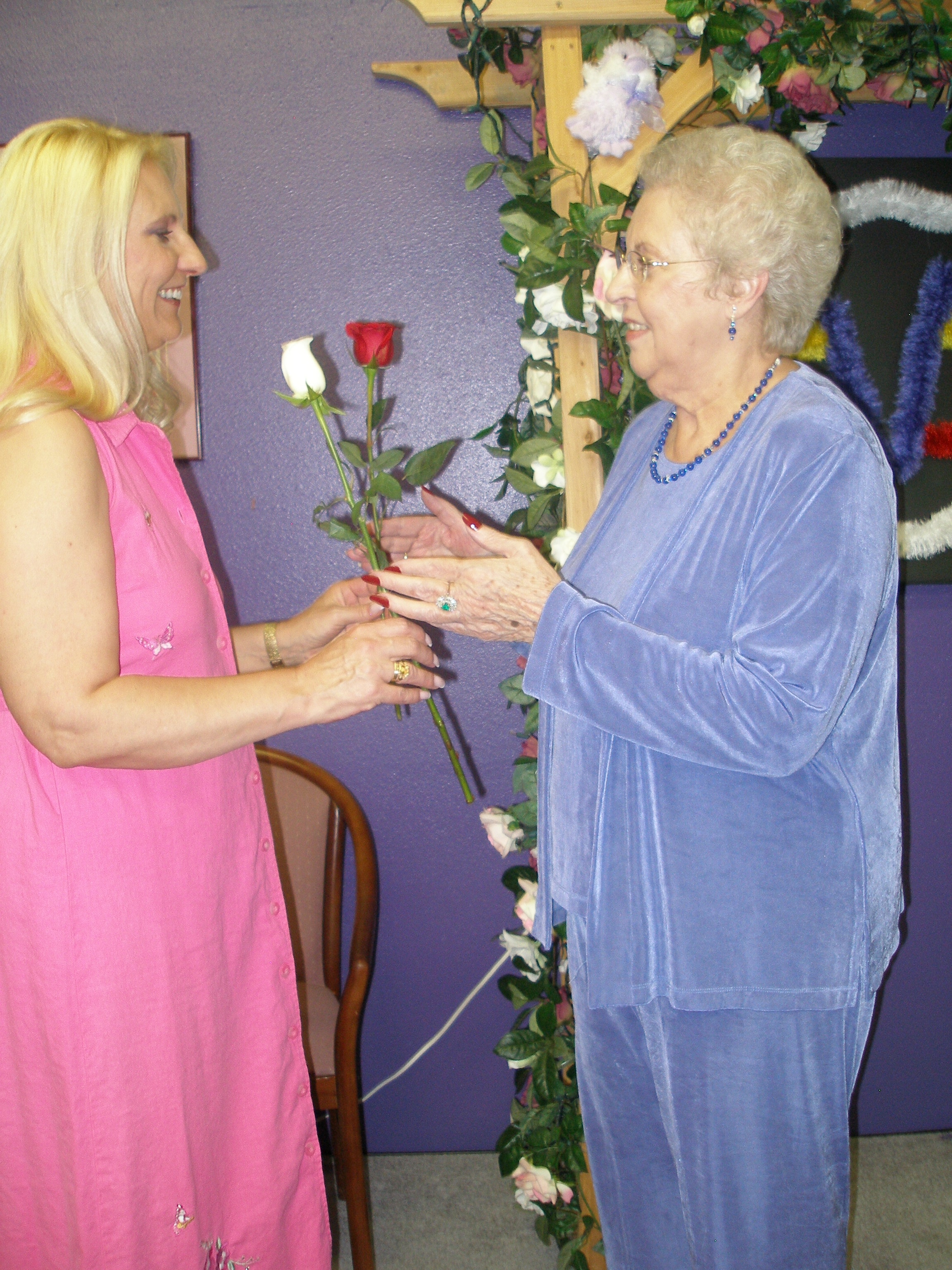 Two women exchanging roses at the Oasis CSL altar