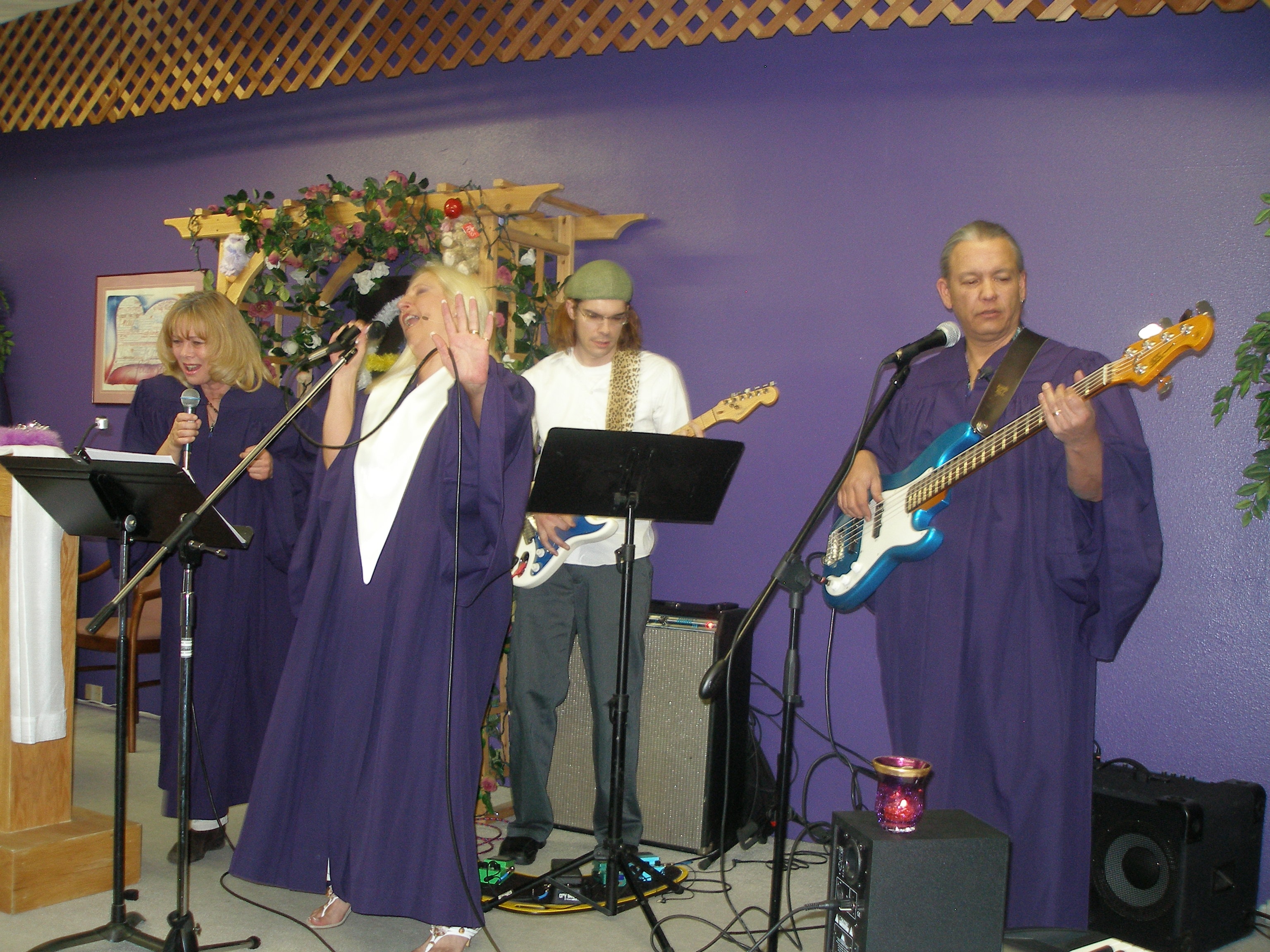 Choir singer raising hand in worship with band at Rev. S. Tucker's ordination
