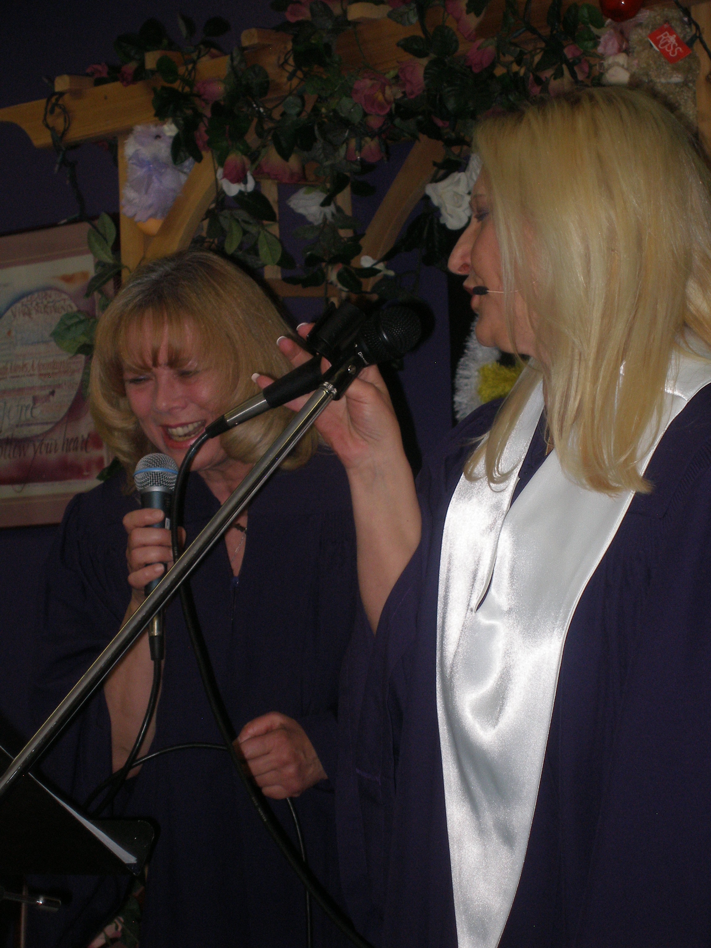 Two women laughing and singing together at Rev. S. Tucker's ordination